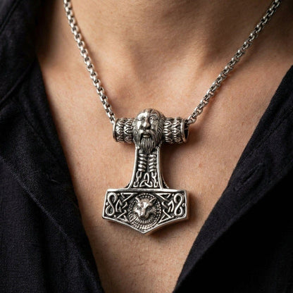 Lifestyle shot of the sterling silver Mjolnir pendant worn on a chain over a black shirt, showing scale and placement.