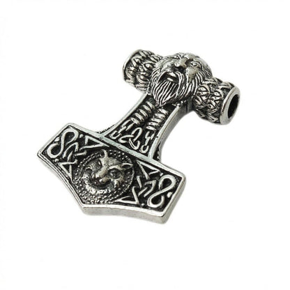 Angled flat lay of the oxidized silver pendant revealing the top chain hole, bearded face bale, and intricate knotwork.
