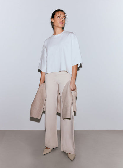 Model wearing a white Luxe Boxy Short Sleeve top and light beige wide-leg pants, holding a light beige jacket. [M-170cm]