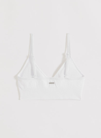 White ribbed seamless sports bra with adjustable straps and metal aim'n logo shown from the back.