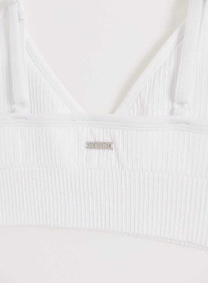 White ribbed seamless sports bra back detail featuring a signature metal aim'n logo badge.