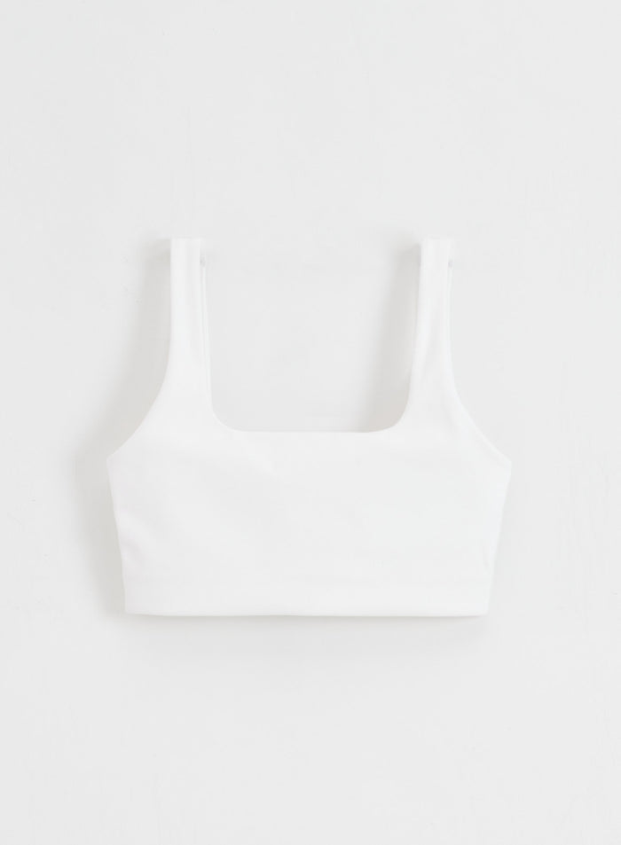 White Sense Bra with a square neck and buttery soft fabric by aim'n, shown in a flatlay.