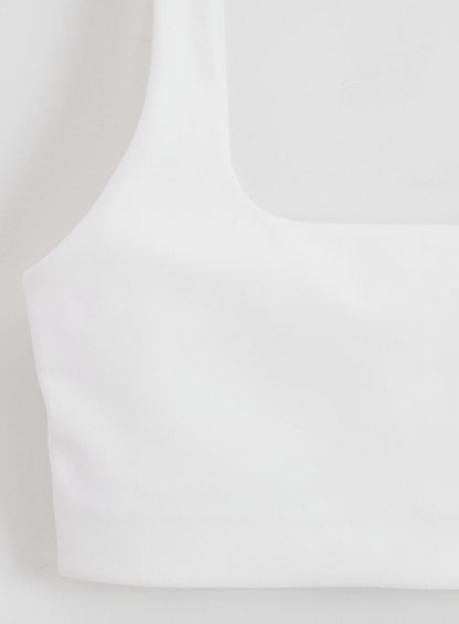Close-up of the white Sense Bra by aim'n featuring a square neckline and buttery soft fabric.