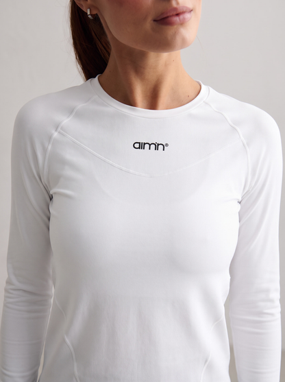 Close-up of a model wearing the white Soft Basic Long Sleeve with the aim'n logo [S-174 cm]