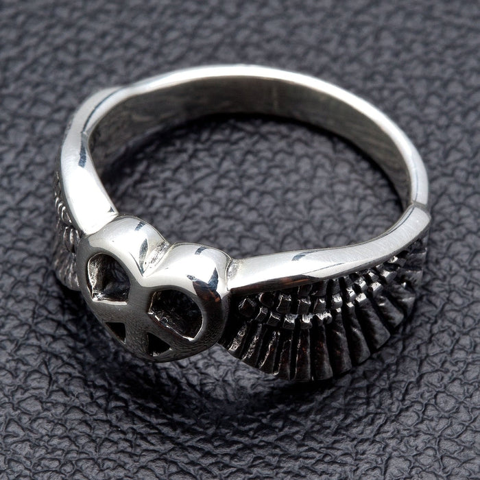 A women's sterling silver ring with a winged heart and peace symbol.