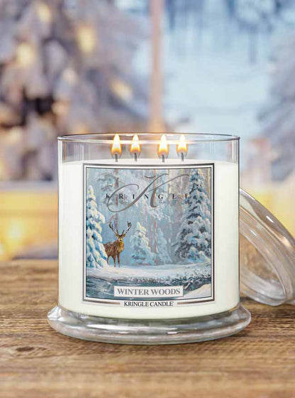 Kringle Candle with 'Winter Woods' design on a wooden surface with blurred background