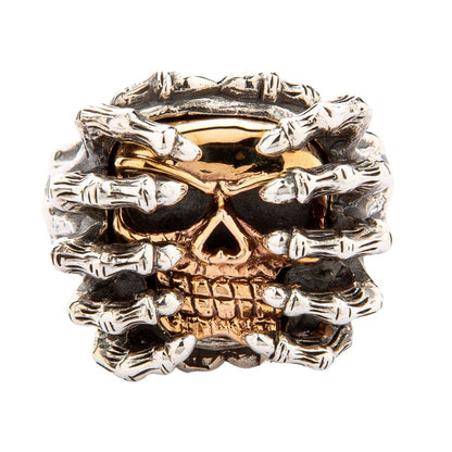 Direct front view highlighting the 14K yellow gold skull face tightly gripped by eight oxidized silver spider legs.