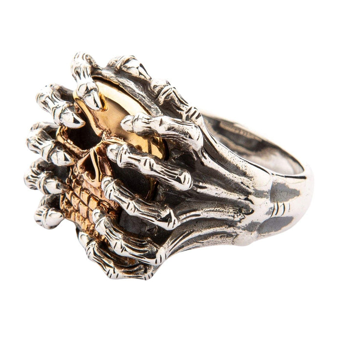 Side profile of the sterling silver band showing textured spider legs curving around the 14K yellow gold skull.